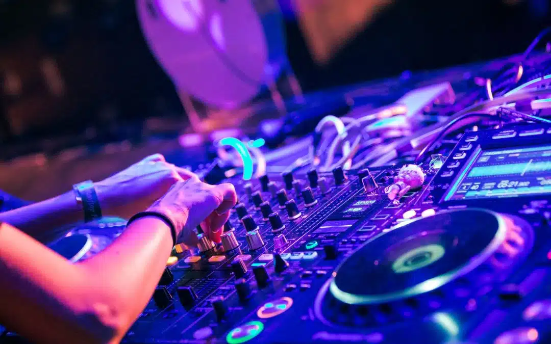 DJ przy konsoli podczas imprezy w świetle reflektorów
